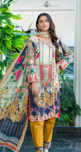 Best salwar suit in kunnamkulam-A woman wearing a colorful printed salwar suit with a yellow bottom stands indoors near green plants.