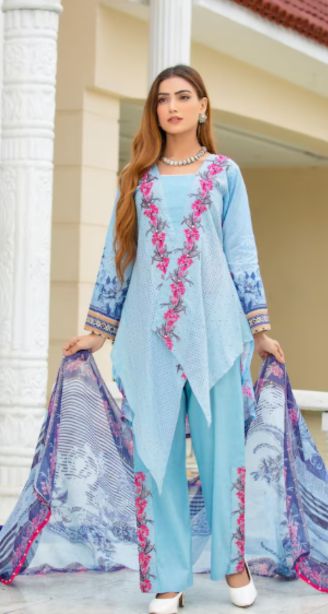 Best salwar suit in kunnamkulam-A woman in a light blue salwar suit with a printed dupatta stands outside near a building.